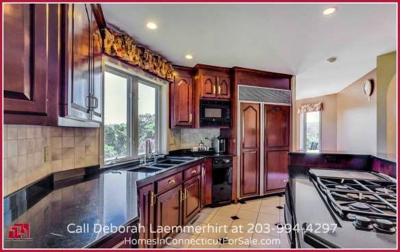 The gourmet kitchen is a chef's delight with its elegance and functionality in the intricate wooden cabinets, granite coutertops and high end appliances.